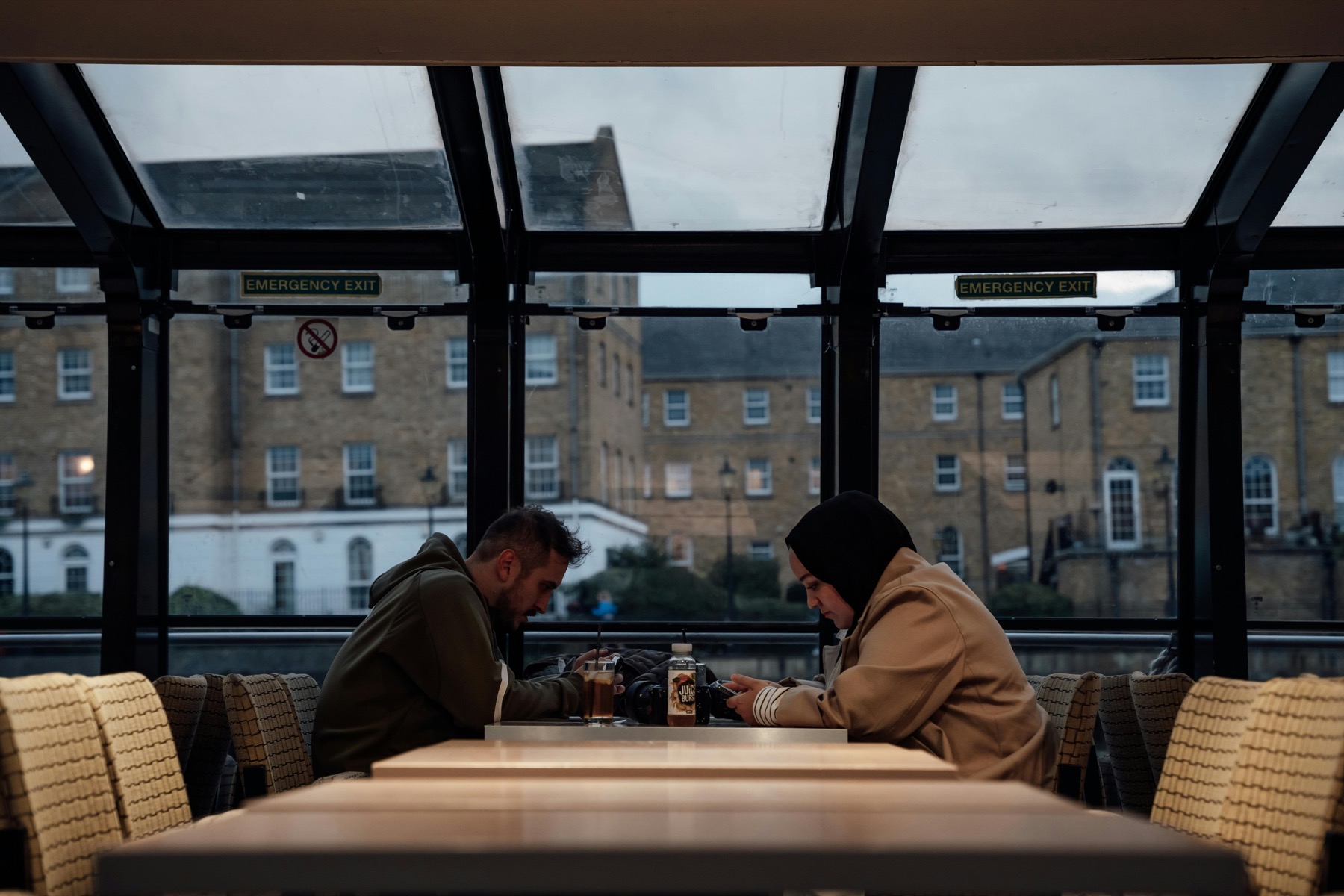 People seated inside a London cafe with a glass roof
